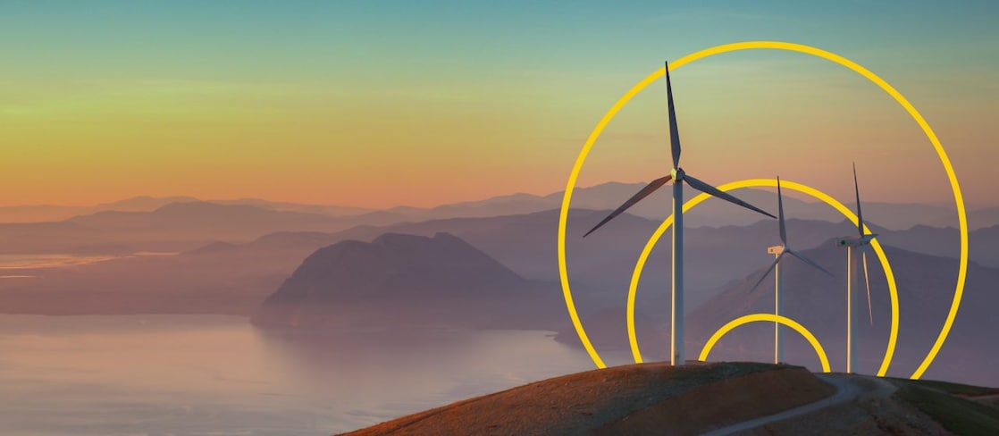 照片:一座山上有三台風力渦輪機,帶有「實現淨零排放」的輪廓圖
