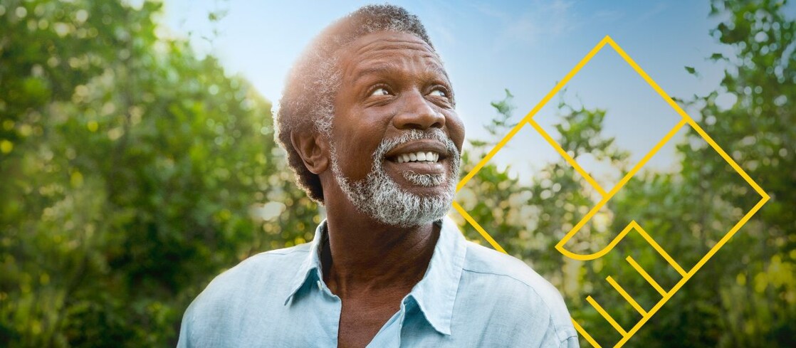 圖片:一名蓄著鬍子的男子微笑著站在樹前,上面有「創造股東價值」的輪廓圖