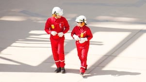 身穿紅色工作服、頭戴白色頭盔和聽力保護裝置行走的男女工人