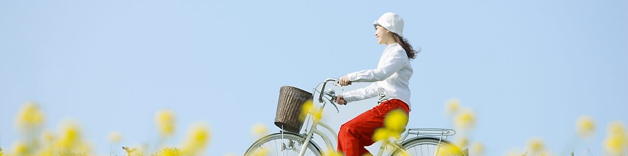 一個年輕女子騎車穿過一片夏天的田野